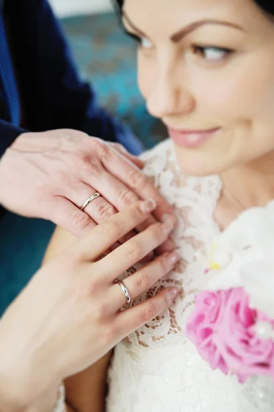 Brudgummen och bruden visar bröllop ringar i vitt guld. Brudgummen — Stockfoto