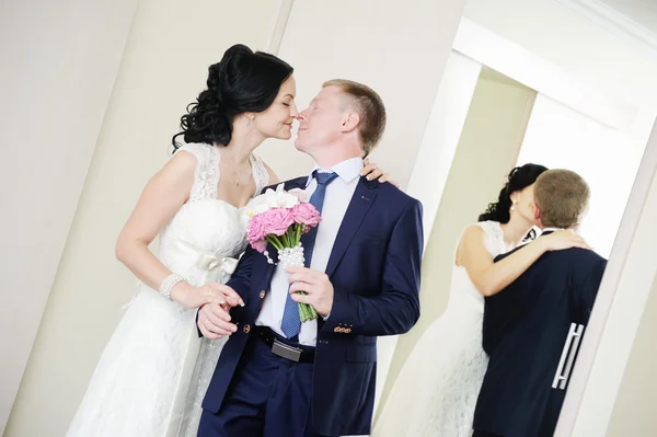 Noiva e noivo beijando no fundo dos espelhos — Fotografia de Stock