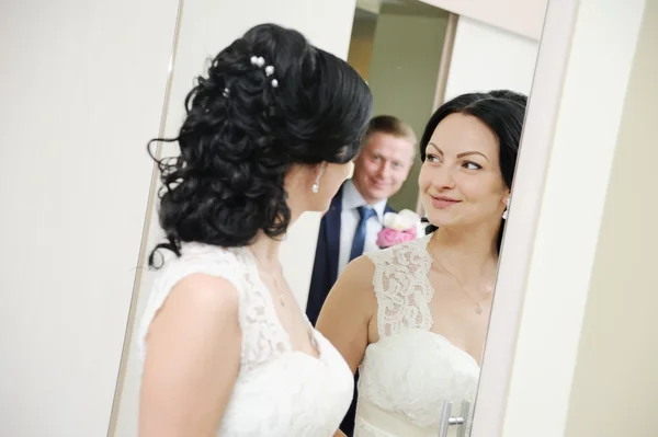 Невеста и жених стоят перед зеркалом — стоковое фото