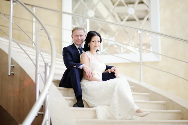 Bride and groom sitting on the stairs — Stock Photo, Image