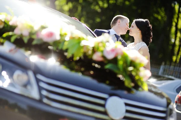 Mariée et marié sur fond de voiture de mariage — Photo