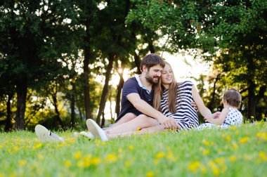 Parkta genç ailesi tatilde. Anne, baba ve küçük 
