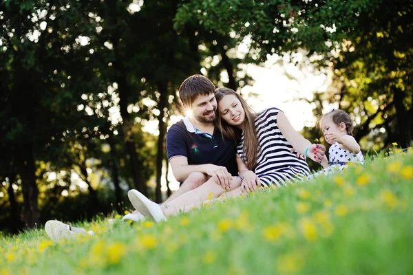 Молодая семья отдыхает в парке. Мать, отец и маленький — стоковое фото