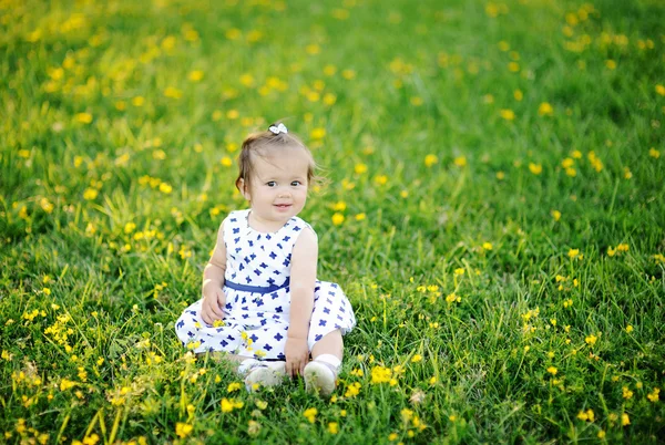 Niña en vestido blanco sentada en la hierba —  Fotos de Stock