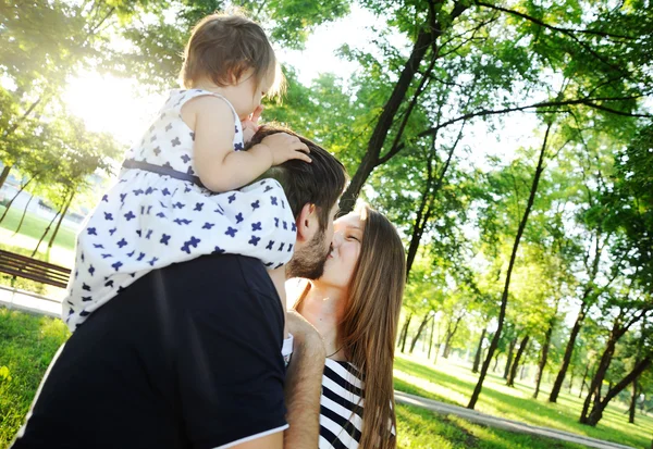 Familia joven en el paseo. Hijita sentada en los hombros —  Fotos de Stock