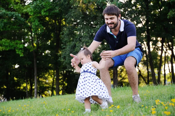 Papá ayuda a su hijita a dar los primeros pasos —  Fotos de Stock