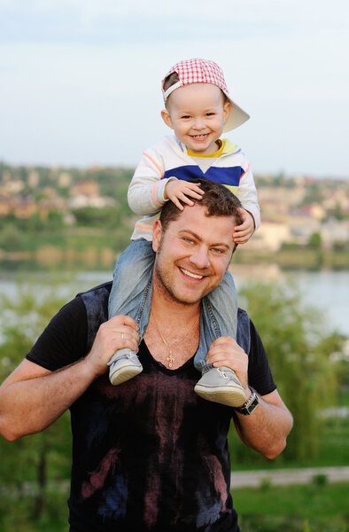 small boy sits on the shoulders of the Pope. Dad and son rest in