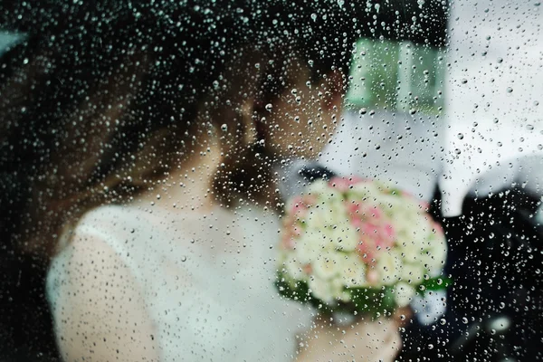 Nevěsta a ženich pro mokré skleněné svatební auto — Stock fotografie
