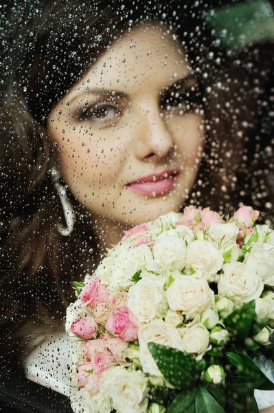 Portrét dívky za mokré sklem. Nevěsta ve svatební auta — Stock fotografie