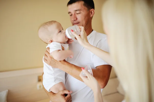 Onun oğlu biberon kollarında, anne beslemeleri bir bebek tutan baba — Stok fotoğraf