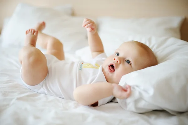 Portrait de bébé aux yeux bleus. Un enfant reposant sur un lit — Photo