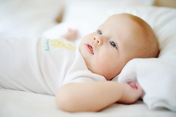 Portrét miminko s modrýma očima. Dítě na lůžku — Stock fotografie