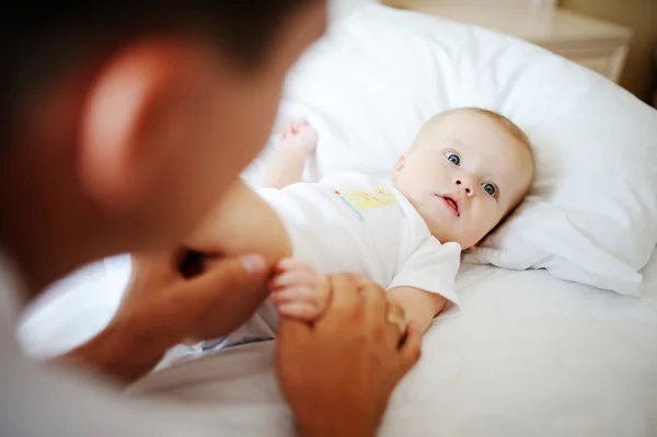 Pai brincando com seu filho na cama — Fotografia de Stock