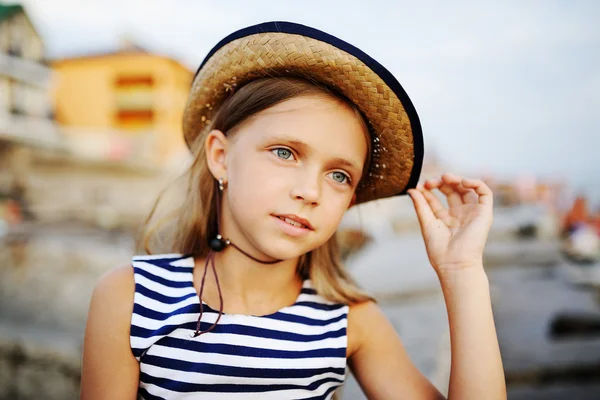 Vacker teen flicka i en randig tröja och en hatt på en bakgrund — Stockfoto