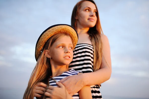 Duas meninas em vestido listrado ao pôr do sol — Fotografia de Stock