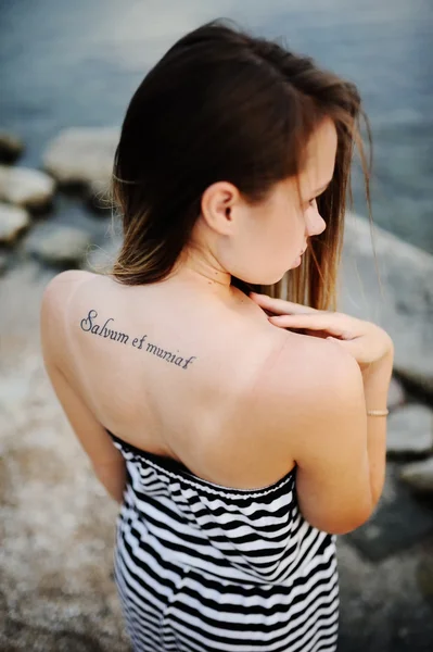 Fille avec un tatouage sur le dos contre la mer — Photo