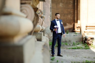 bir eski buildin arka planda bir düğün buket ile damat