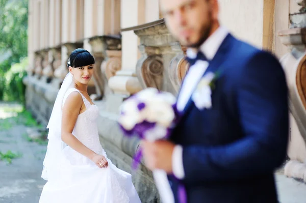 La mariée et le marié sur le fond d'un vieux bâtiment avec co — Photo