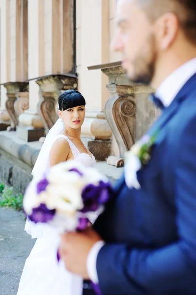 La mariée et le marié sur le fond d'un vieux bâtiment avec co — Photo