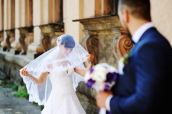 Bruden och brudgummen på bakgrund av en gammal byggnad med co — Stockfoto