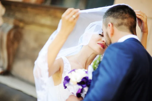 Brudparet kysser under slöjan — Stockfoto