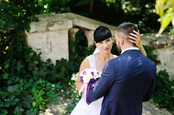 Bruden och brudgummen på bakgrund av grönska — Stockfoto