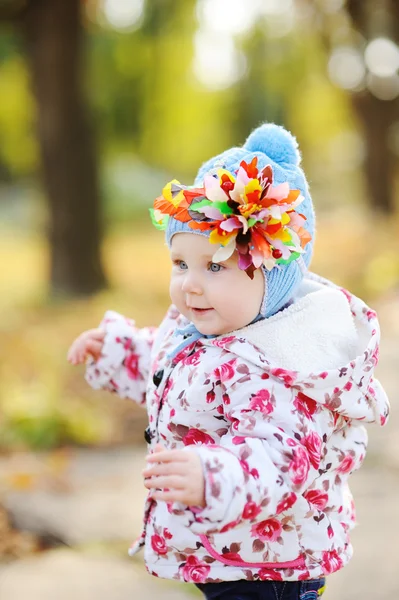 Bebé niña con aro de colores en la cabeza sobre un fondo de autu —  Fotos de Stock