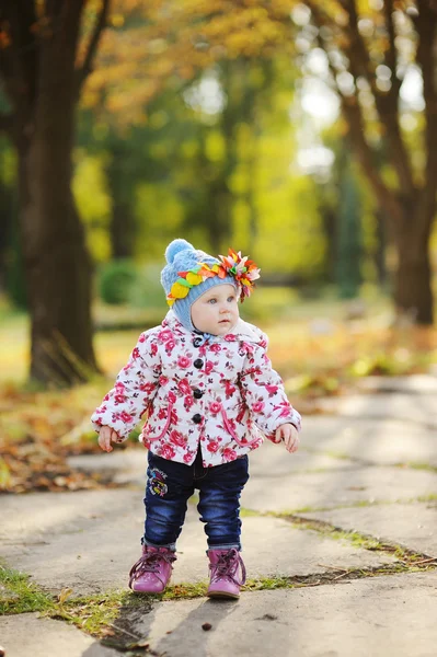 Bebé niña con aro de colores en la cabeza sobre un fondo de autu —  Fotos de Stock