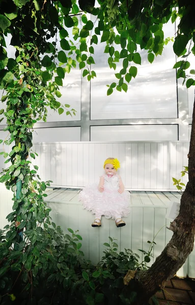 Bambina seduta su uno sfondo verde — Foto Stock