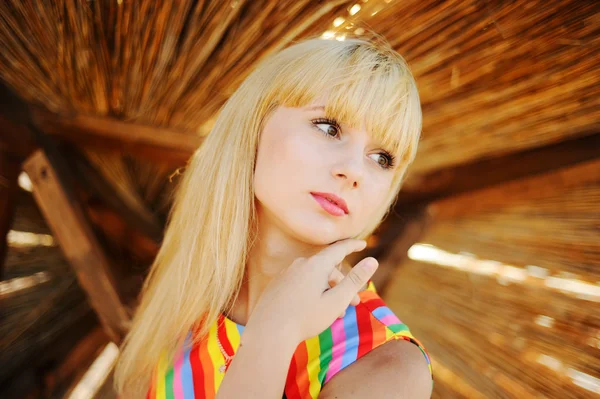 Girl in a colorful sundress on the beach — Stock Photo, Image