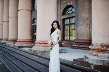 Gelin bir eski bui arka plan üzerinde bir düğün buketi ile