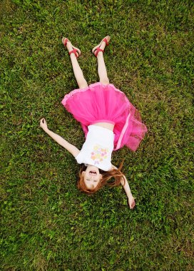 Kızıl saçlı kız parkta çim üzerinde rahatlatıcı