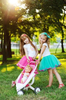 oyuncak çocuk arabası ile iki küçük kız