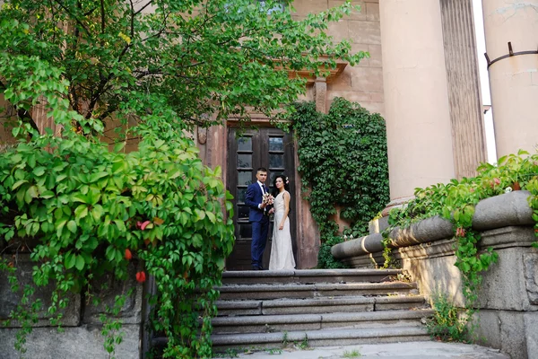 La mariée et le marié avec un bouquet de mariage sur le fond de — Photo