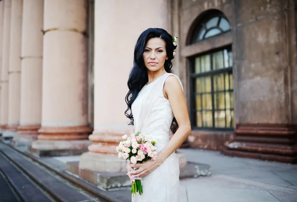 Невеста со свадебным букетом на фоне старого буя — стоковое фото