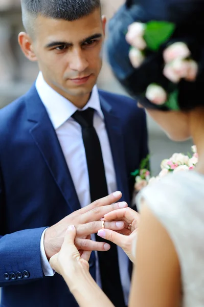 Bride groom wears a wedding ring — Stock Photo, Image