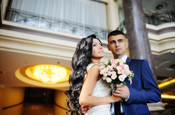 De bruid met een boeket van de bruiloft op de achtergrond van de bruidegom — Stockfoto