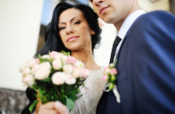 De bruid met een boeket van de bruiloft op de achtergrond van de bruidegom — Stockfoto