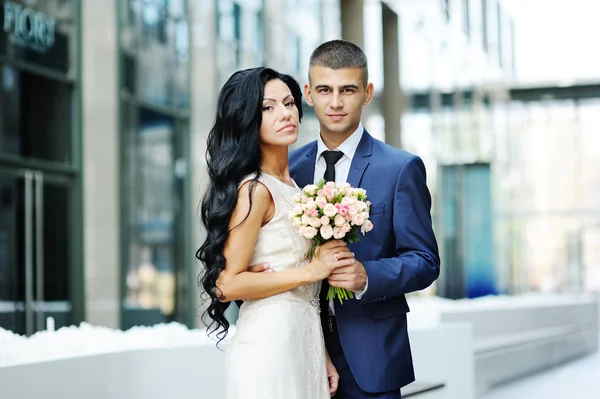 La mariée et le marié sur le fond du bâtiment en verre — Photo