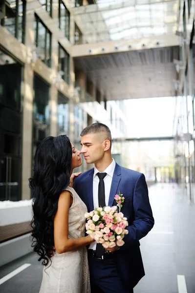 La novia y el novio en el fondo de la construcción de vidrio —  Fotos de Stock
