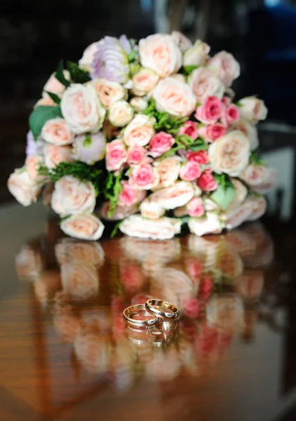 Los anillos de boda sobre el fondo del ramo de la novia — Foto de Stock