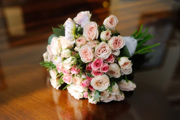 Un ramo nupcial de rosas sobre la mesa — Foto de Stock