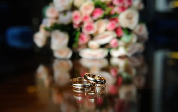 A háttérben a menyasszony csokor esküvői Jegygyűrűk — Stock Fotó