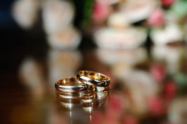 Los anillos de boda sobre el fondo del ramo de la novia — Foto de Stock