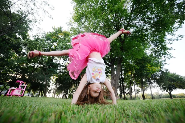 Grappig roodharige meisje ontspannen op het gras in het park — Stockfoto