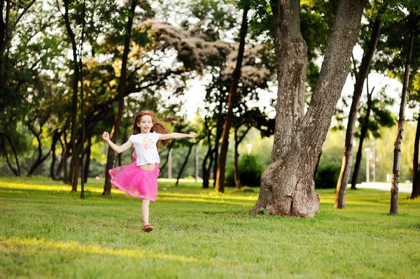 Haired little girl runs across the grass — Stock Photo, Image