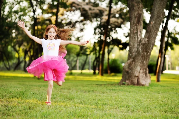 Haired little girl runs across the grass — Stock Photo, Image