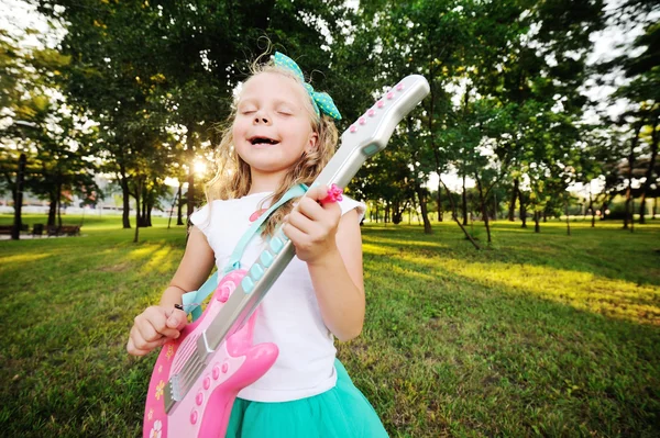 Menina com uma guitarra de brinquedo — Fotografia de Stock