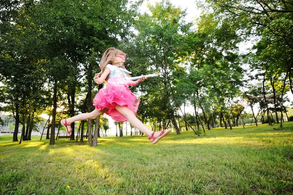 Девочка прыгает с игрушечной гитарой — стоковое фото