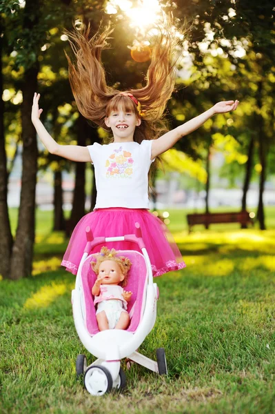 Baby girl carries a doll in the pram — Stock Photo, Image